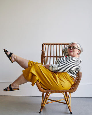 Person reclining in a chair in a striped t-shirt and yellow pants. This top is the Stanway Raglan T-Shirt sewing pattern from "Ahead of the Curve" by Jenny Rushmore.