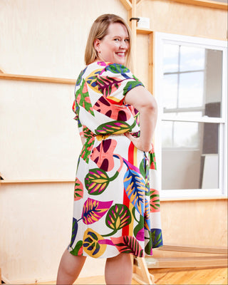 Woman wearing a colorful dress with leaf patterns in an indoor setting. This dress is the Kineton Dress & Top sewing pattern from Cashmerette.