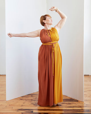 Woman wearing a two-tone dress standing in a room with wooden flooring and white walls. This dress is the Rockwell Dress sewing pattern from Cashmerette.