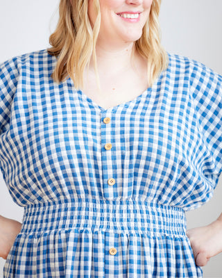 Person wearing a blue and white checkered dress with a plain background. This dress is the Franconia Dress sewing pattern from Cashmerette.