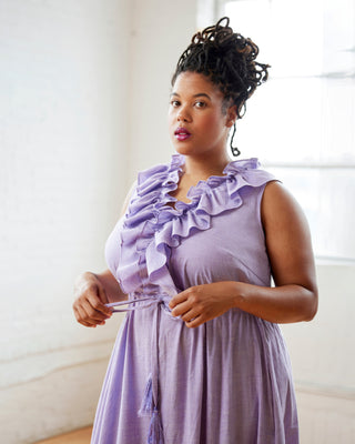 Woman wearing a lavender dress with ruffled details against a neutral background. This dress is the Loring Dress sewing pattern from Cashmerette.