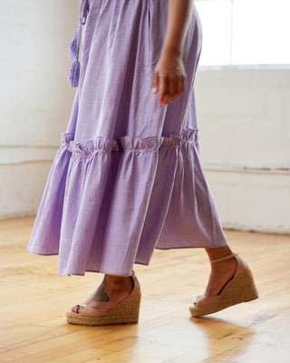 Person wearing a purple dress with ruffled layers on a wooden floor. This dress is the Loring Dress sewing pattern from Cashmerette.