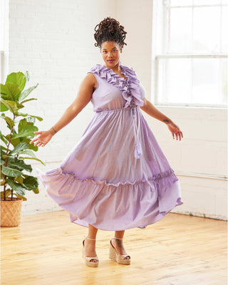 Woman wearing a light purple dress with ruffles in a bright room. This dress is the Loring Dress sewing pattern from Cashmerette.