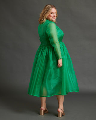 Woman wearing a green dress against a gray background. This dress is the Mansfield Dress sewing pattern from Cashmerette.