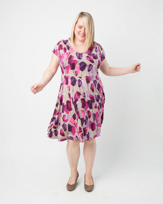 Woman wearing a floral dress on a white background. This dress is the Turner Dress sewing pattern from Cashmerette.