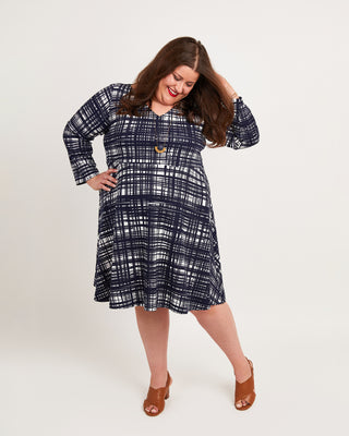Woman wearing a blue plaid dress on a white background. This dress is the Turner Dress sewing pattern from Cashmerette.