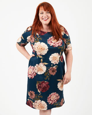 Woman wearing a floral dress on a white background. This dress is the Rivermont Dress & Top sewing pattern from Cashmerette.