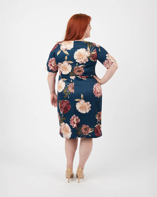 Woman wearing a floral dress on a white background. This dress is the Rivermont Dress & Top sewing pattern from Cashmerette.