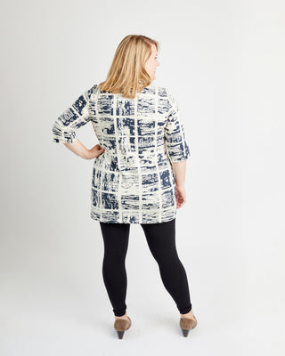 Woman wearing a patterned shirt and black leggings on a white background. This is the Pembroke Dress & Tunic sewing pattern from Cashmerette.