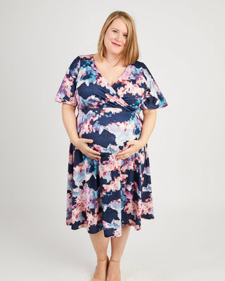Woman wearing a floral dress on a white background. This dress is the Alcott Dress sewing pattern from Cashmerette.