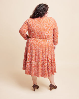 Woman wearing a patterned dress on a beige background. This is the Grafton Dress, Top & Skirt sewing pattern from Cashmerette.