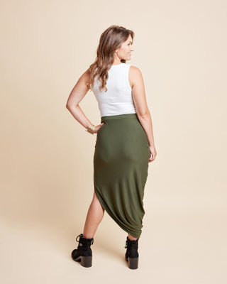 Woman wearing a white top and green skirt on a beige background. This is the Grafton Dress, Top & Skirt sewing pattern from Cashmrette.