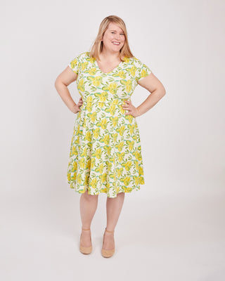 Woman wearing a yellow floral dress on a white background. This is the nursing expansion pack sewing pattern from Cashmerette.