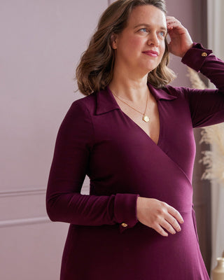 Woman wearing a purple dress against a pink wall