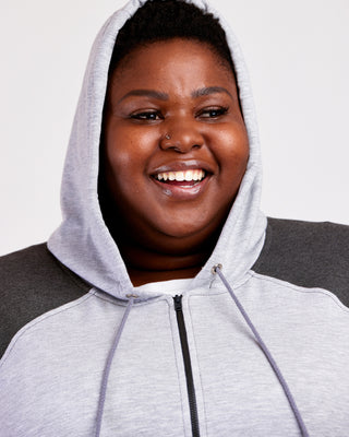 Person wearing a gray hoodie against a plain background. This hoodie is the Stanton Hoodie sewing pattern from Cashmerette.