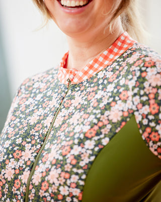 Person wearing a floral jacket with a checkered collar, smiling. This top is the Bonair Athletic Top sewing pattern from Cashmerette.