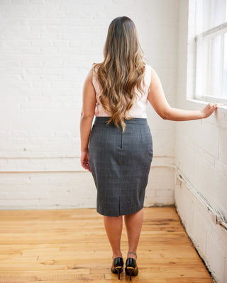 Woman wearing a gray skirt standing in a room with wooden floor and white walls. This skirt is the Elmwood Pencil Skirt sewing pattern from Cashmerette.