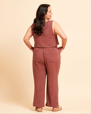 Woman wearing a brown sleeveless top and pants against a beige background. These pants are the Everett Pants & Shorts sewing pattern from Cashmerette.