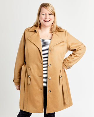 Woman wearing a tan coat on a white background. This coat is the Chilton Trench Coat sewing pattern from Cashmerette.