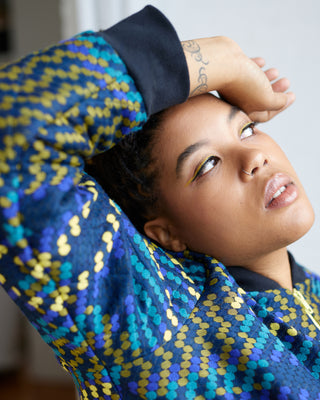 Person wearing a colorful patterned garment with a blurred background. This jacket is the Cashmerette Club Kimball Bomber Jacket sewing pattern.