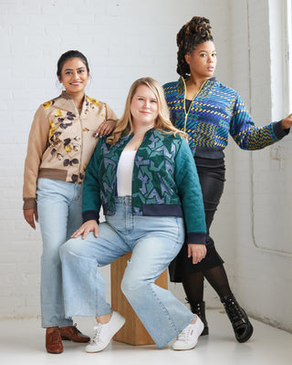 Three women posing together wearing patterned jackets against a white wall. This jacket is the Cashmerette Club Kimball Bomber Jacket sewing pattern.
