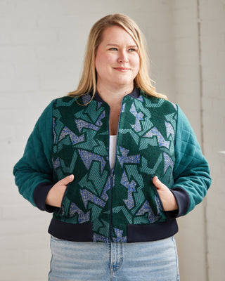 Person wearing a green patterned jacket with a plain background. This jacket is the Cashmerette Club Kimball Bomber Jacket sewing pattern.