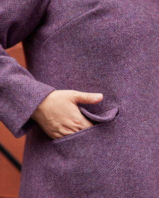 Close-up of a person wearing a purple coat with a hand in the pocket. This coat is the Newcomb Car Coat sewing pattern from Cashmerette.