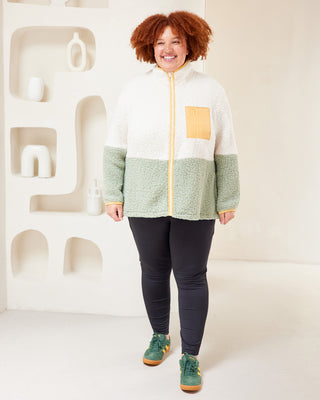 Person wearing a green and white jacket with a yellow zipper against a white background. This jacket is the Hatton Fleece Jacket sewing pattern from Cashmerette.