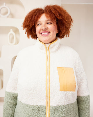 Person wearing a white and green fleece jacket with a yellow zipper, standing against a neutral background. This jacket is the Hatton Fleece Jacket sewing pattern from Cashmerette.