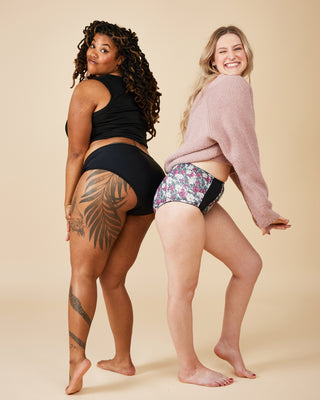 Two women standing side by side wearing underwear on a beige background. These undies are the Radcliffe Undies sewing pattern from Cashmerette.