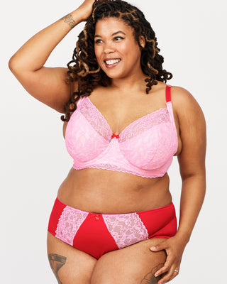 Woman wearing a pink and red lingerie set on a white background. This bra is the Willowdale Bra sewing pattern from Cashmerette.