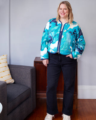 Person wearing a colorful jacket in a living room setting. This jacket is the Fairfax Quilted Jacket sewing pattern from "Sewing the Curve" by Jenny Rushmore.