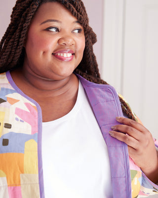 Woman wearing a colorful quilted jacket with a white shirt underneath, against a light background. This jacket is the Fairfax Quilted Jacket sewing pattern from "Sewing the Curve" by Jenny Rushmore.