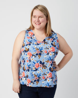 Woman wearing a blue floral sleeveless top against a white background. This is a pattern hack of the Springfield Top from the Pattern Hacking for Curves class.