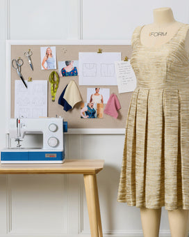 Sewing station with a dress on a mannequin and sewing machine.