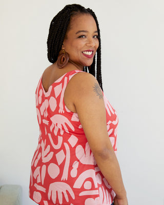 Woman wearing a red and white patterned sleeveless top against a plain background. This top is the Kersoe Top sewing pattern from "Ahead of the Curve" by Jenny Rushmore.