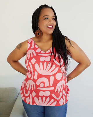 Woman wearing a red tank top with white abstract patterns against a plain background. This top is the Kersoe Top sewing pattern from "Ahead of the Curve" by Jenny Rushmore.