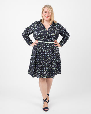 Woman wearing a black patterned dress on a white background. This dress is the Lenox Shirtdress sewing pattern from Cashmerette.