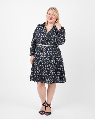Woman wearing a black patterned dress on a white background. This dress is the Lenox Shirtdress sewing pattern from Cashmerette.