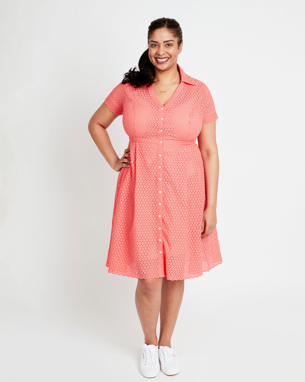 Woman wearing a coral dress with a white background. This dress is the Lenox Shirtdress sewing pattern from Cashmerette.