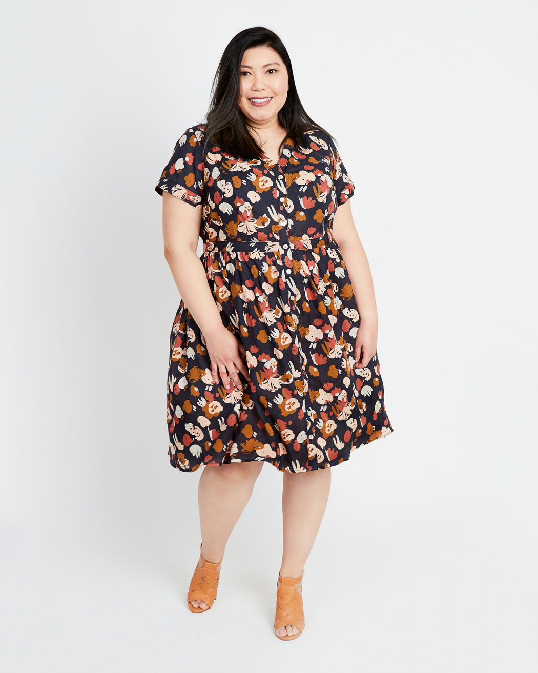 Woman wearing a floral dress on a white background. This dress is the Lenox Shirtdress sewing pattern from Cashmerette.
