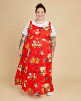 Person wearing a red floral dress on a beige background. This is the Holyoke Maxi Dress & Skirt sewing pattern from Cashmerette.