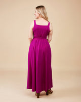 Woman wearing a long magenta dress on a beige background. This is the Holyoke Maxi Dress & Skirt sewing pattern from Cashmerette.