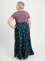 Woman wearing a purple top and blue patterned skirt on a white background. This is the Holyoke Maxi Dress & Skirt sewing pattern from Cashmerette.