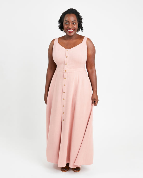 Woman wearing a pink sleeveless dress with buttons on a white background. This is the Holyoke Maxi Dress & Skirt sewing pattern from Cashmerette.