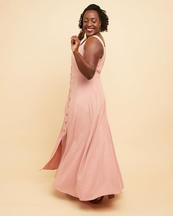 Woman wearing a pink dress against a beige background. This is the Holyoke Maxi Dress & Skirt sewing pattern from Cashmerette.