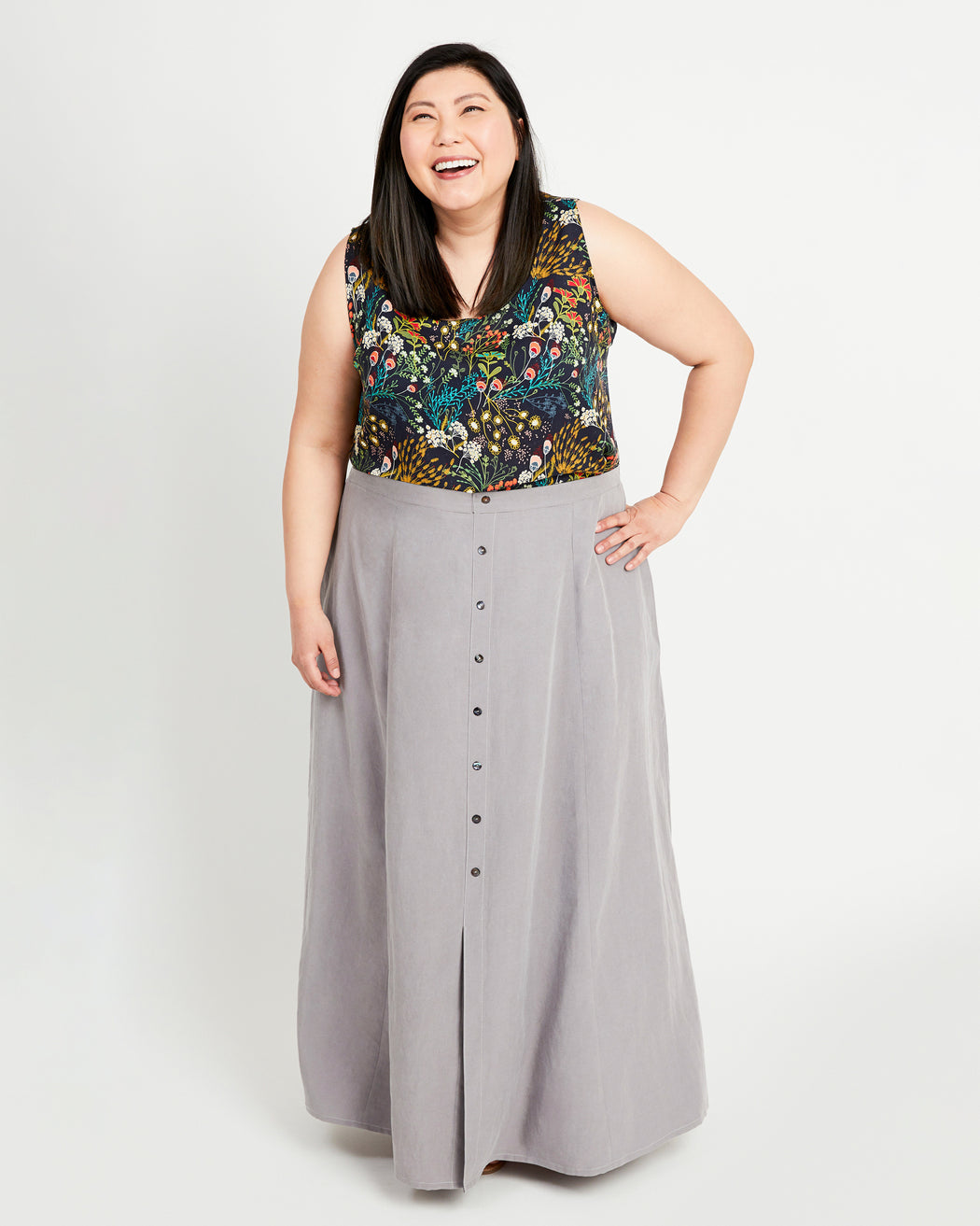 Woman wearing a floral top and gray skirt on a white background. This is the Holyoke Maxi Dress & Skirt sewing pattern from Cashmerette.