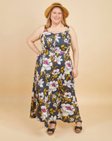 Woman wearing a floral dress with a beige background. This is the Holyoke Maxi Dress & Skirt sewing pattern from Cashmerette.