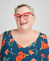 Person wearing a blue floral dress with red glasses on a white background. This dress is the Upton Dress & Skirt sewing pattern from Cashmerette.