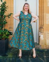 Woman wearing a blue and gold patterned dress standing outdoors. This dress is the Upton Dress & Skirt sewing pattern from Cashmerette.